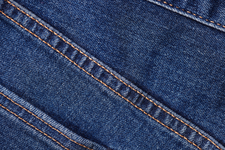 Detailaufnahme einer sauberen Doppelnaht auf blauem Jeansstoff.