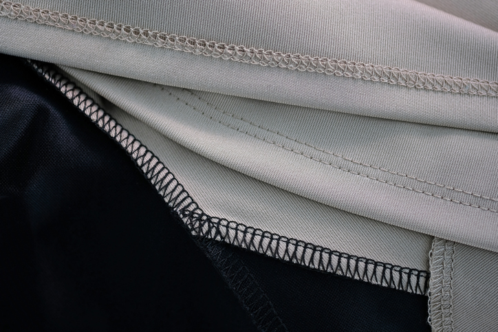 Stoffkante mit sauberer Overlock-Naht in Schwarz und Beige.